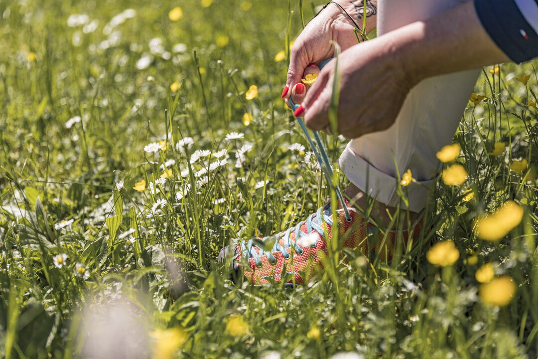 Frau bindet sich die Wanderschuhe